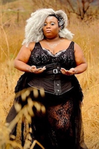 Rawiyah, aka Irene McCalphin (they/them)  as  Star! Rawiyah  is a witch, healer, art activist, and storyteller. For over a decade, Rawiyah has woven music with spoken word and song to create cathartic pieces that center Blackness, Fatness and Queerness. A former member of the award winning and internationally traveled troupe Rubenesque Burlesque and co-founder and lead of  A Sovereign Embodiment  they continue to highlight body and soul liberation in their solo career. Their art is often political /ritual and is rooted in a vulnerability that can be both humorous and heartbreaking. For information, bookings and connects find them at  www.mammyisdead.com.